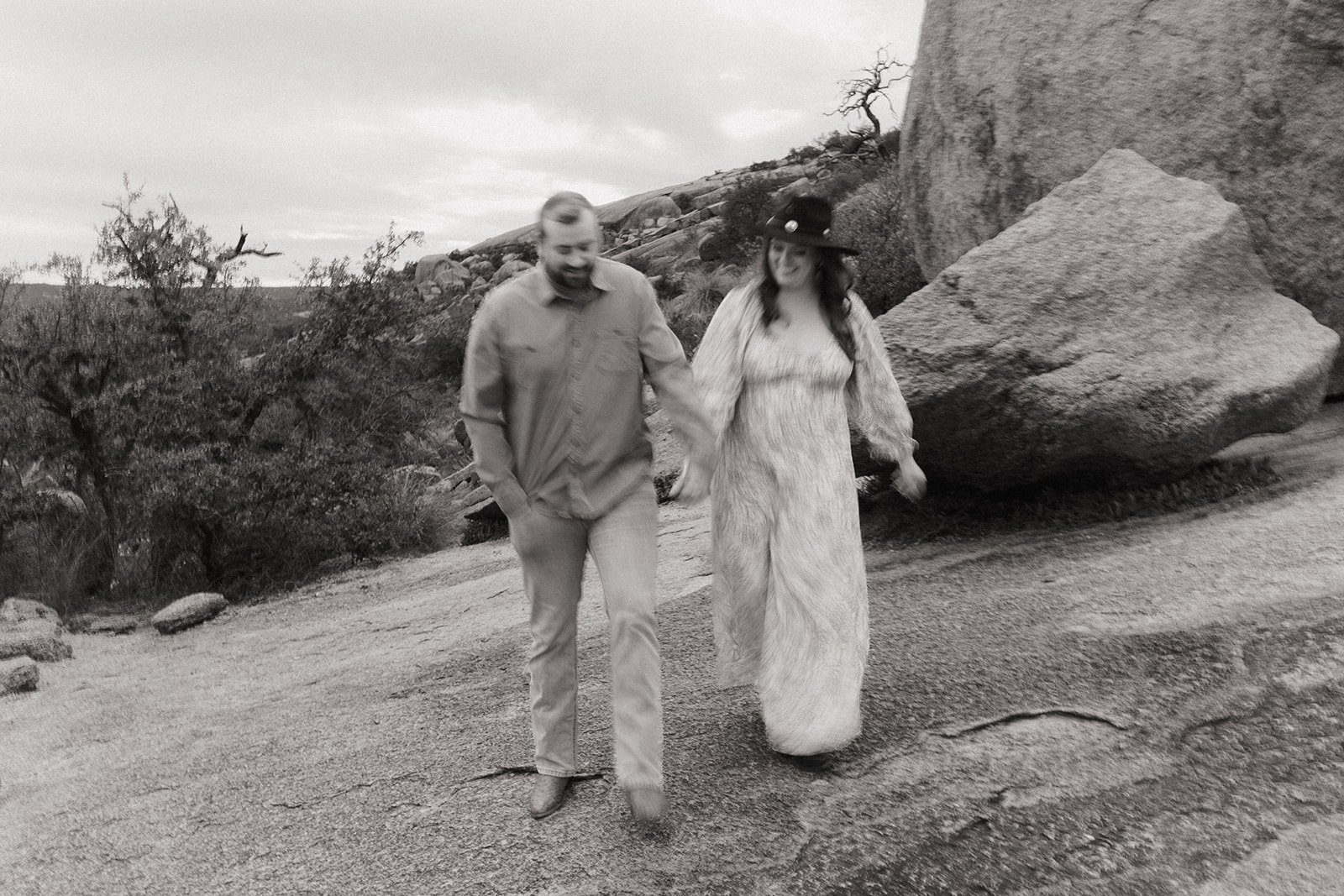 A gorgeous blurry action shot of the couple traversing the rock hand in hand