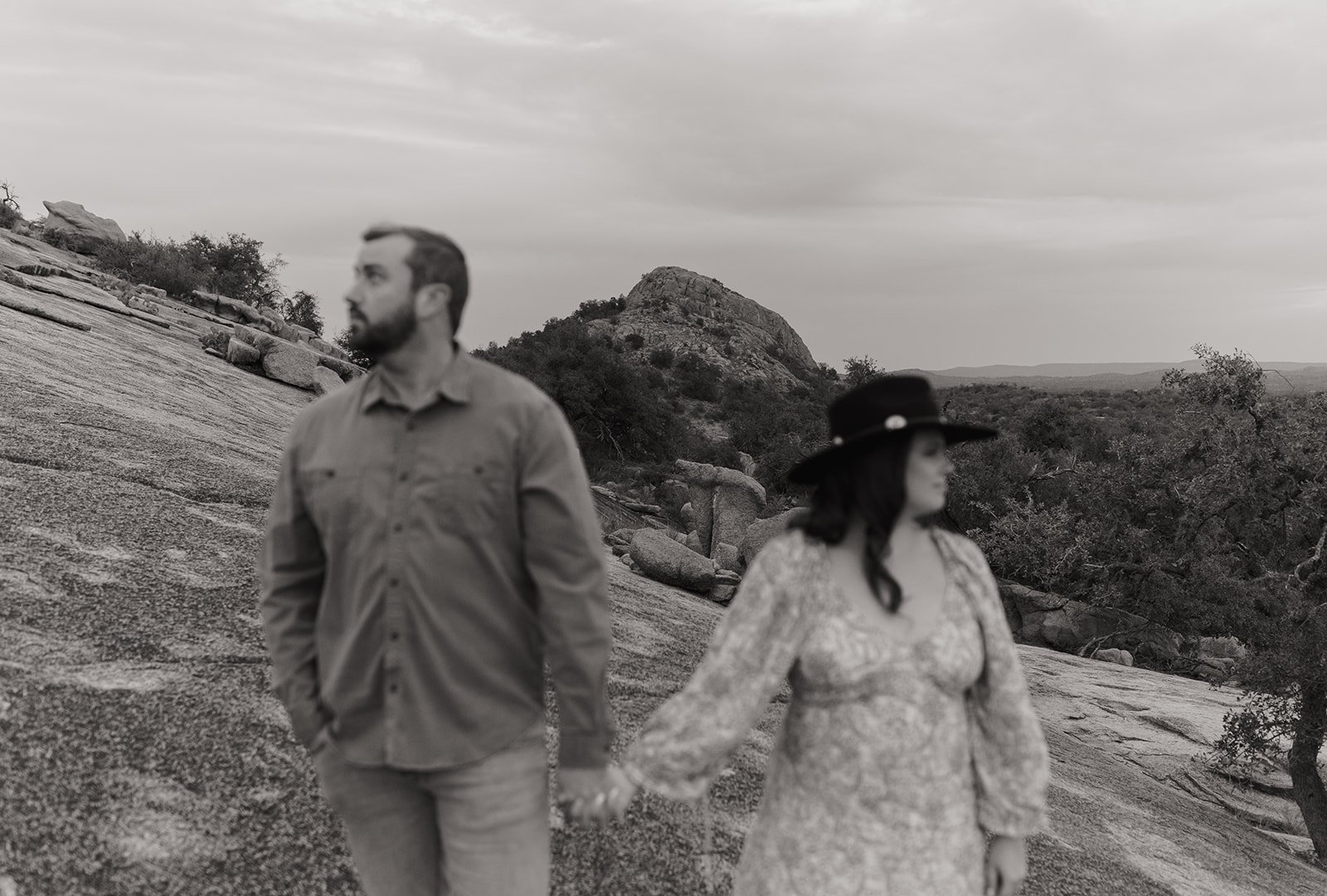 Moody and hazy black and white shot of the couple and the wide open horizon behind them