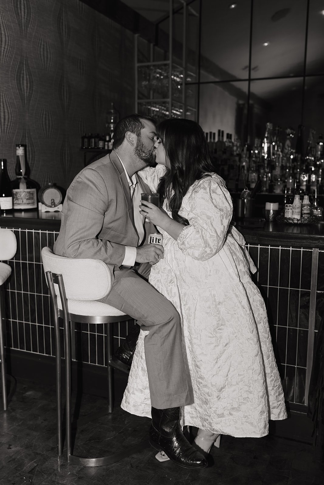 A black and white shot of the couple kissing at the Sage Restaurant's bar