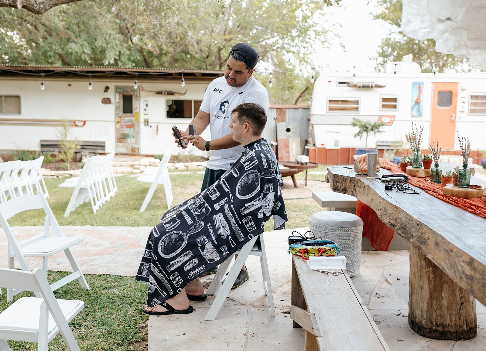 James getting a haircut before the ceremony on the beautiful outdoor grounds of the camp