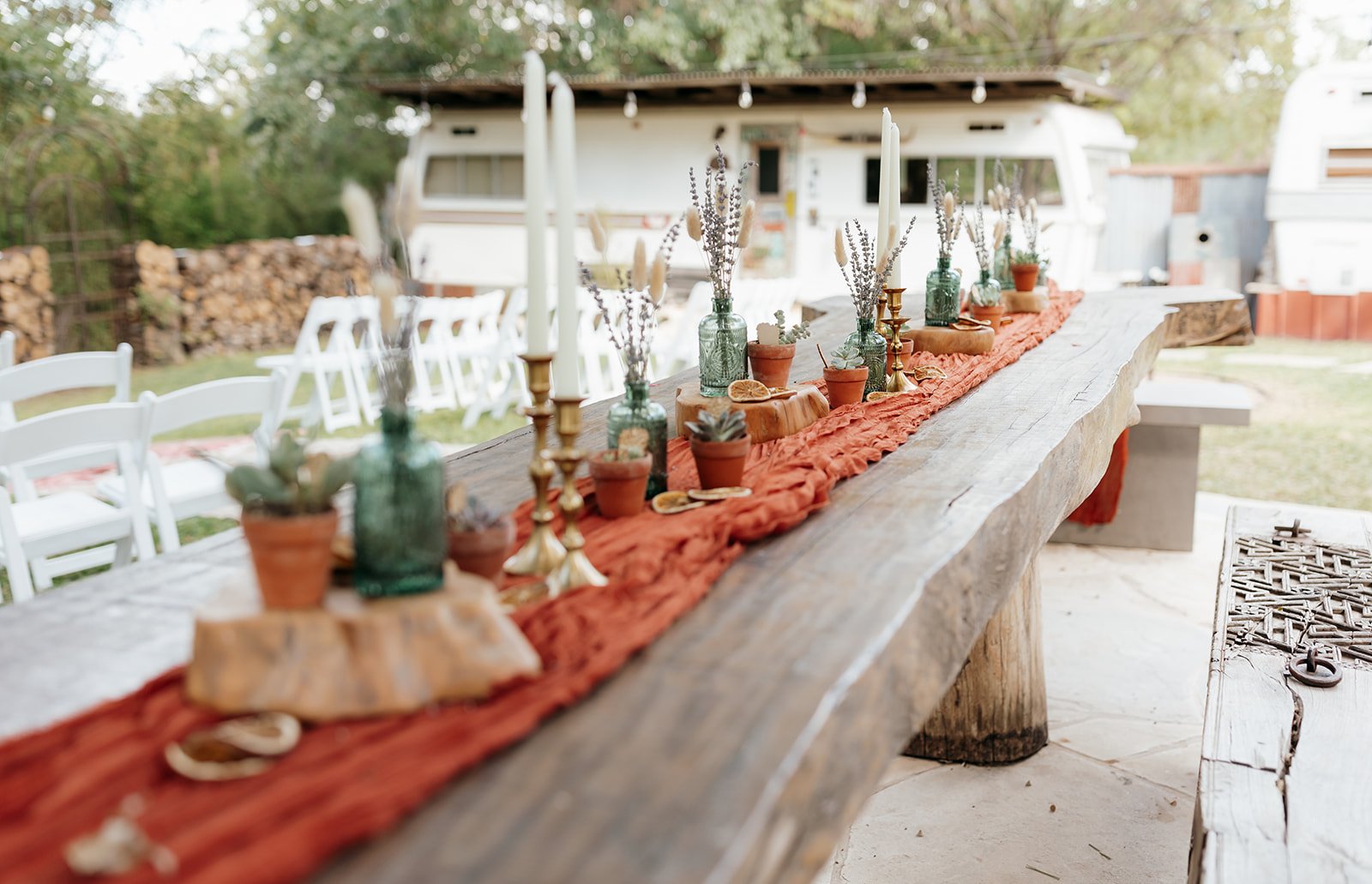 Another angle of the DIY rust-orange wedding table setting with vingtage campers in the background
