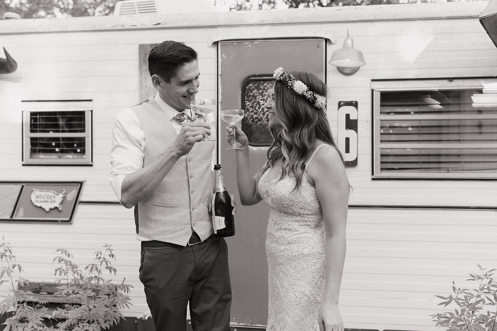 Black and white photo of Leah and James sharing champagne