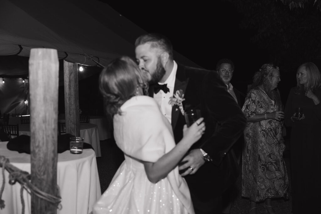Grainy vintage cinematic aesthetic photograph of couple kissing and dancing at Jackson Hole wedding reception