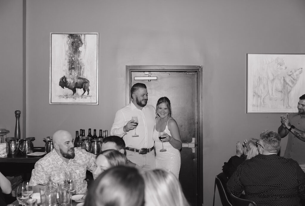 Couple toasting guests at their rehearsal dinner at Gather Restaurant and Bar 
