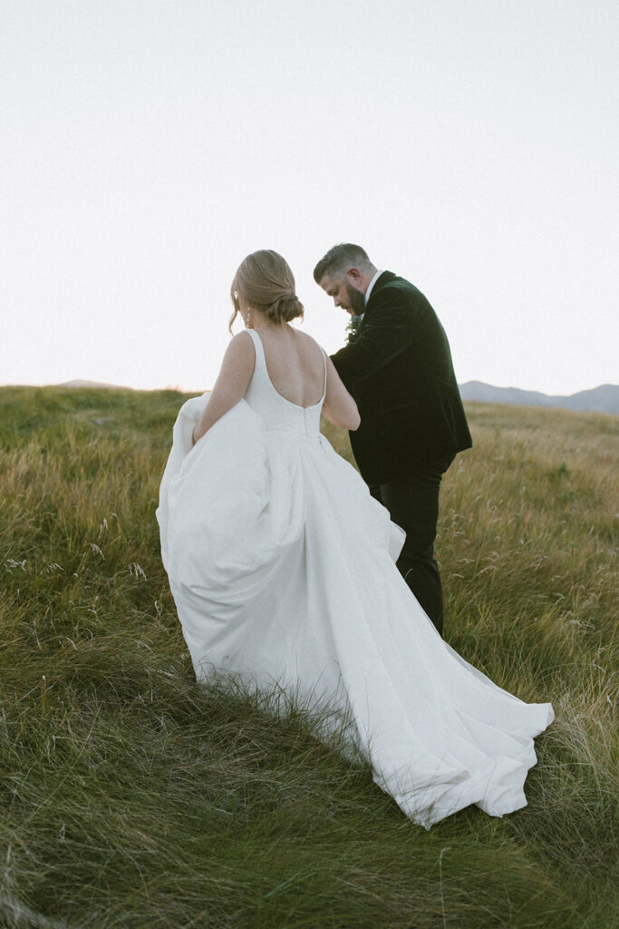 Candid and cinematic mountain wedding portraits at dusk in a mountain meadow of Jackson Hole, Wyoming