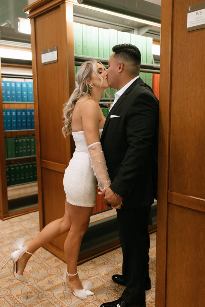 The couple sneaking kisses in the book stacks of the historic Texas State Capitol for their downtown Austin engagement session