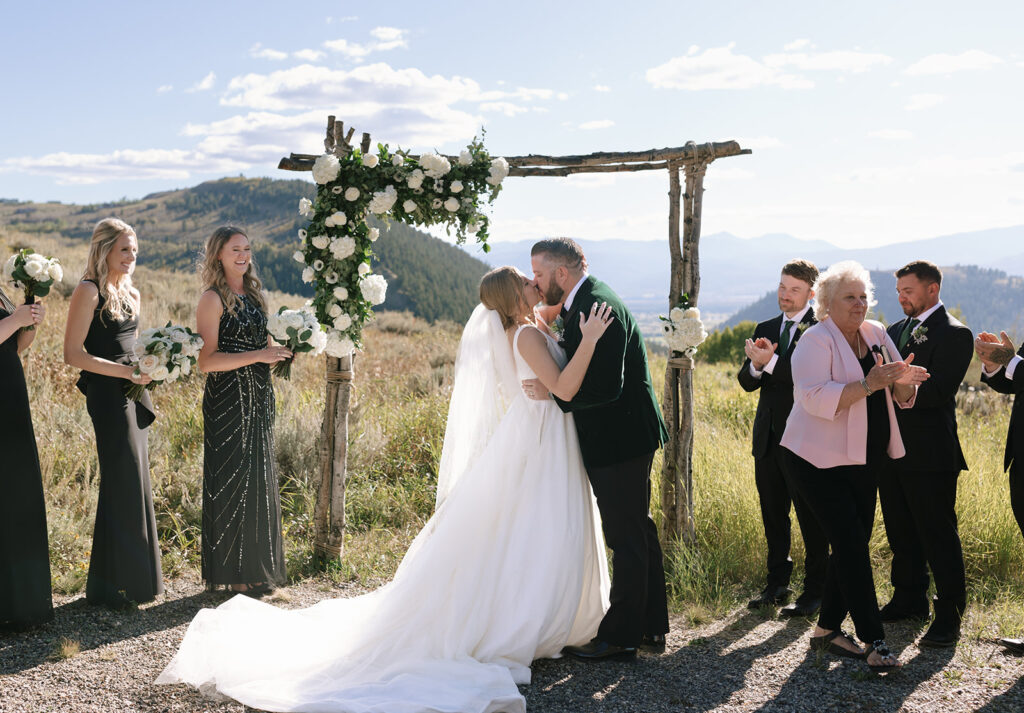 The first kiss as husband and wife at during their dream Wyoming mountain wedding