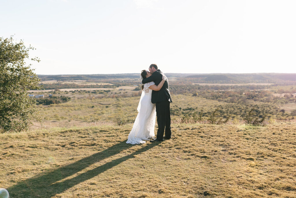 First kiss as husband and wife overlooking the scenic Texas Hill Country views of Contigo Ranch