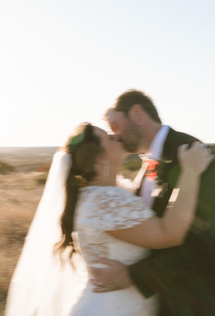 Cinematic and a little blurry photo of the couple at golden hour during their Texas Hill Country wedding
