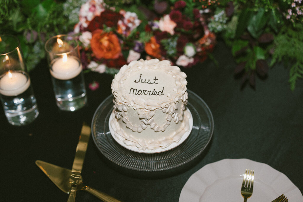 White wedding cake that reads: Just married in black icing
