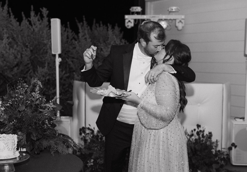 The couple kissing during the cake cutting at their Contigo Ranch wedding reception