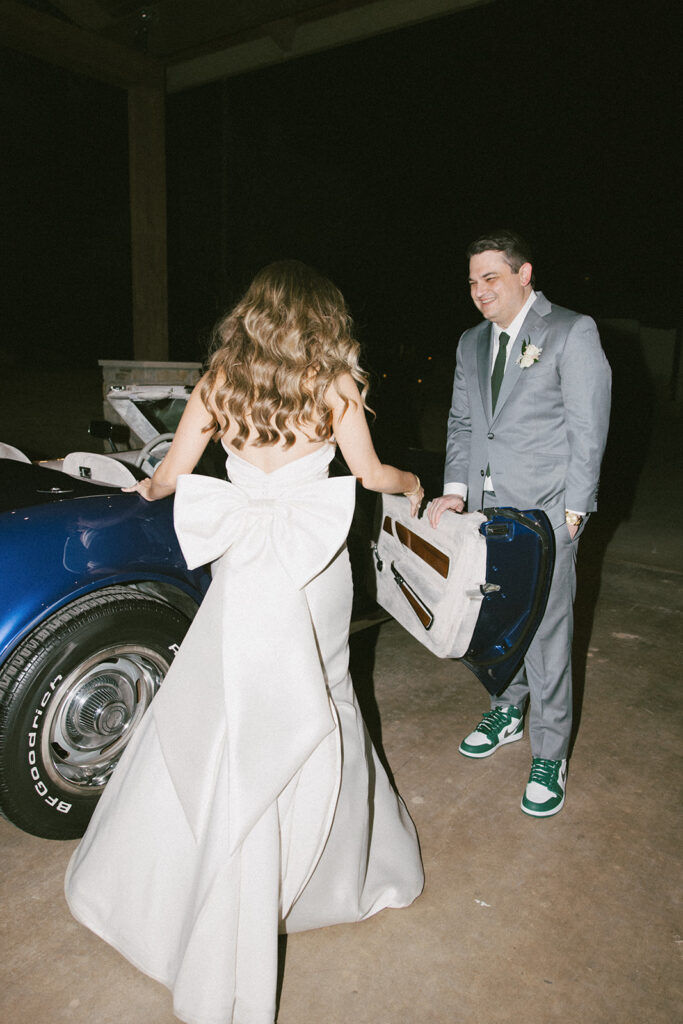 Flash night photography of Lara and Jordan getting in the classic Corvette during their romantic winter wedding
