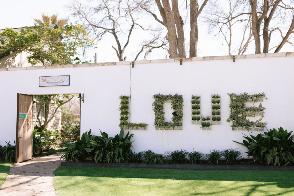Plants spell out 'love' on the wall leading to the Hummingbird House in Austin Texas