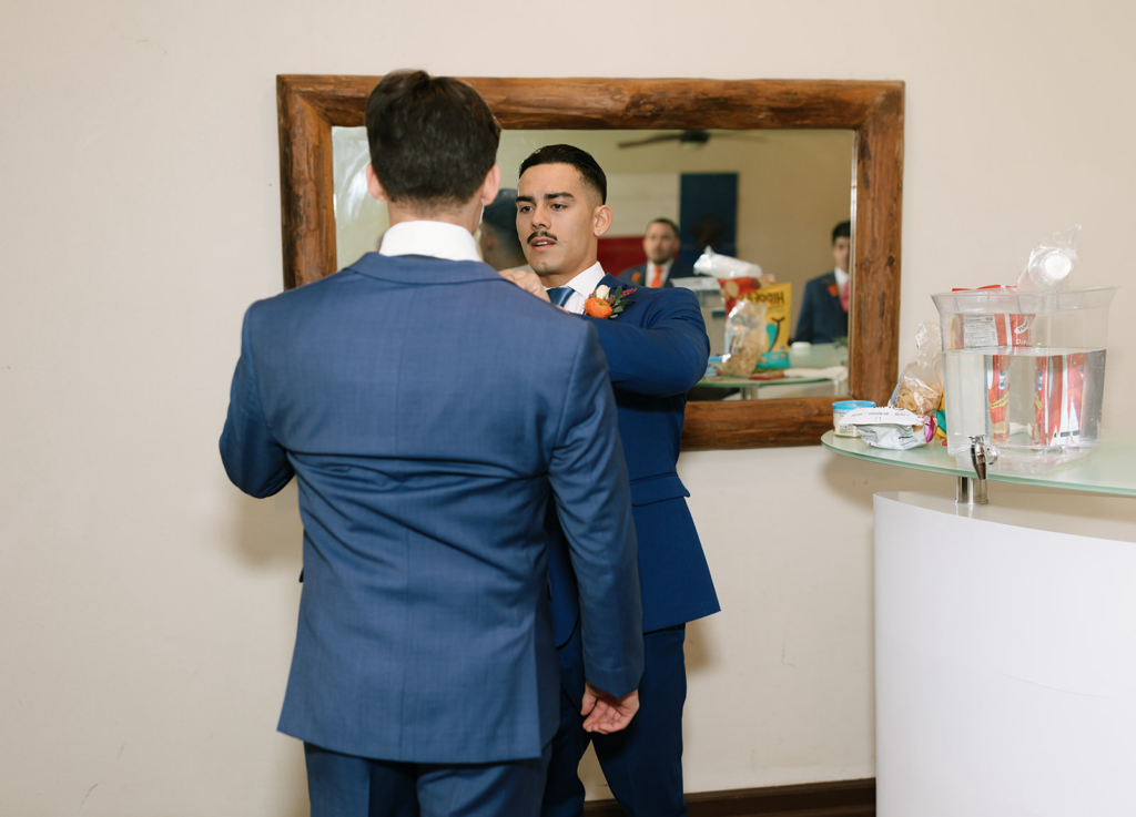 Joshua helping out a younger groomsmen get ready at the Hummingbird House Austin