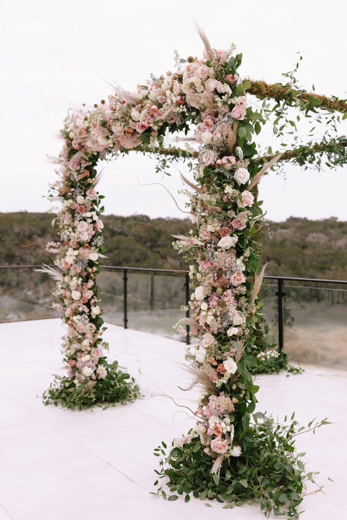 Romantic winter wedding chuppah overflowing with stunning soft pink and white florals