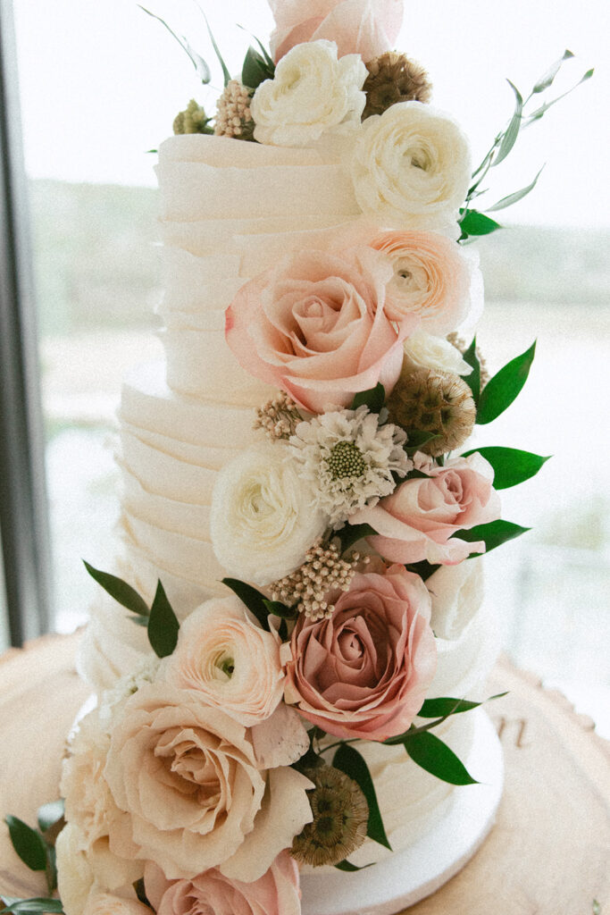 Elegant and romantic white wedding cake with soft white and pink florals