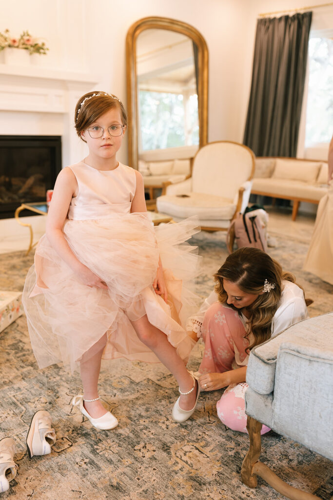 Lara helping the flower girl into her ballet shoes