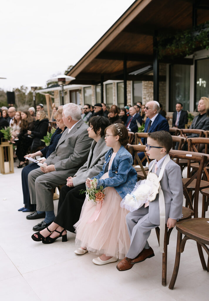 The ring bearer and flower girl watching the ceremony