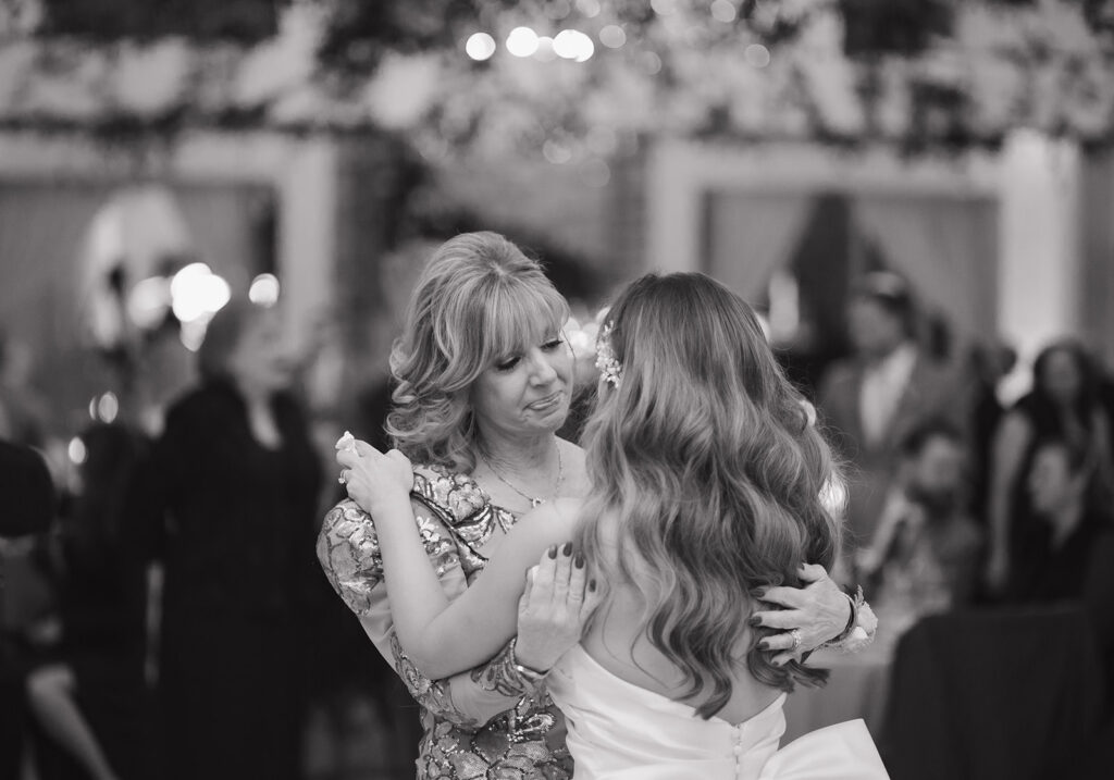 Emotional mother-daughter dance moment in black and white