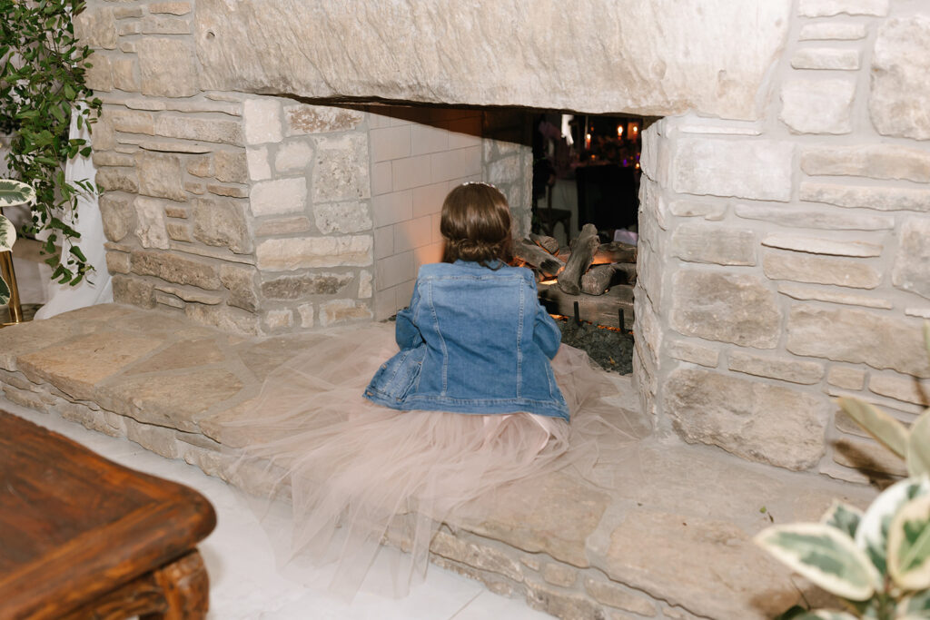 The flower girl warming up in front of the Videre Estate's reception hall fireplace