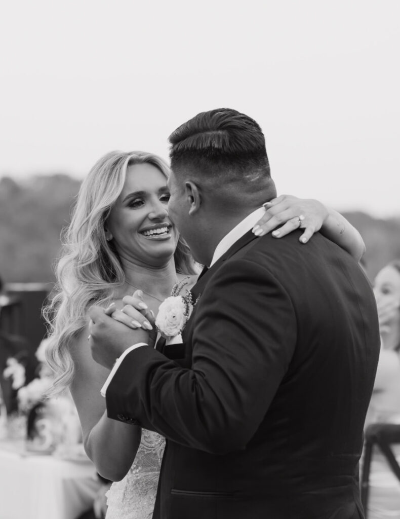 Bride and groom during their first dance smiling with so much joy and love