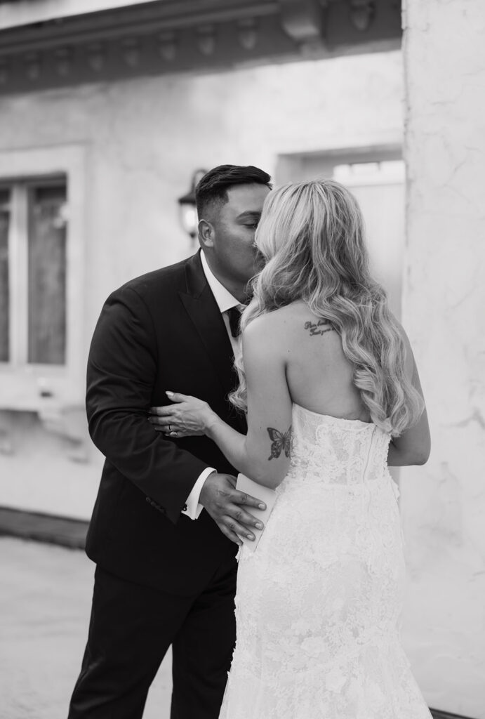 Romantic wedding moment of bride and groom sharing a kiss outside Villa Antonia after their private vow exchange