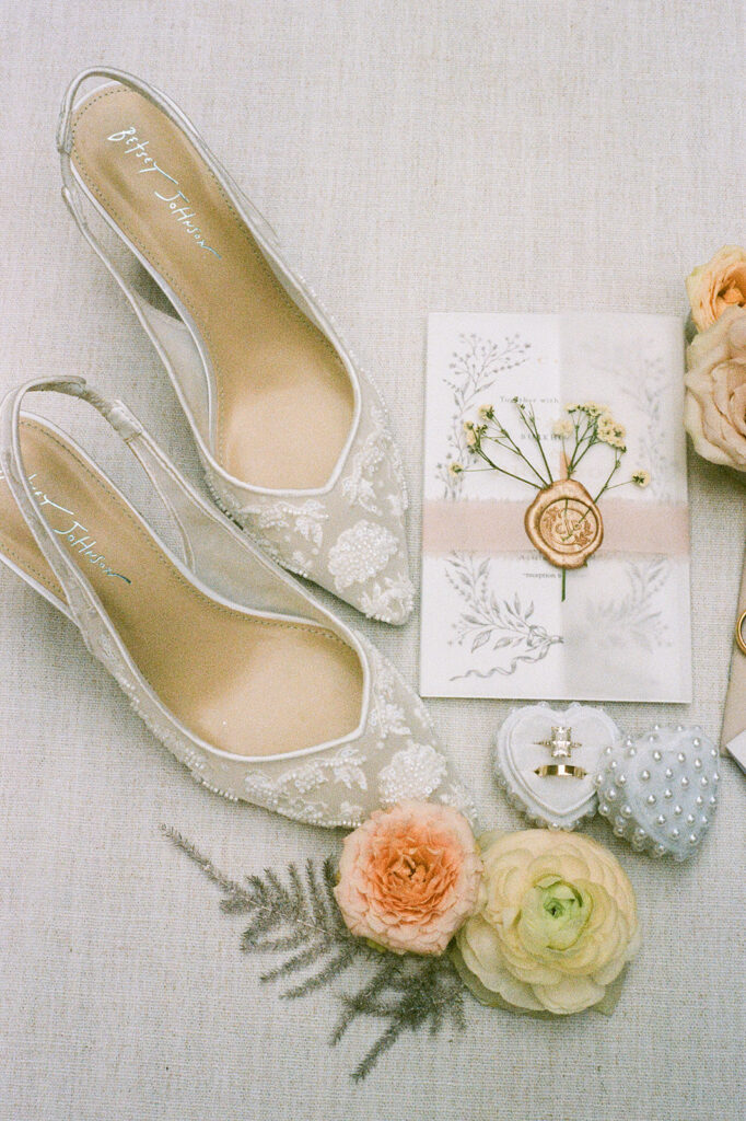 Elegant wedding details at Villa Antonia wedding, featuring lace bridal shoes, pastel florals, pearl encrusted ring box and more on 35mm film