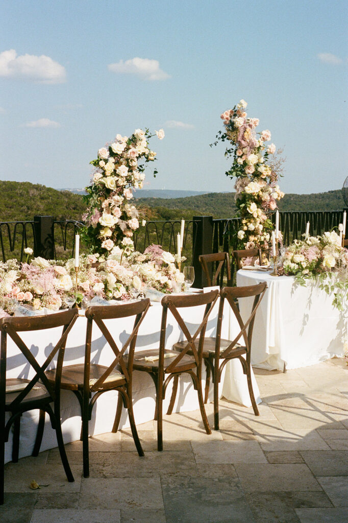 Outdoor wedding reception table with floral decor and Austin hill country views at Villa Antonia wedding on 35mm film