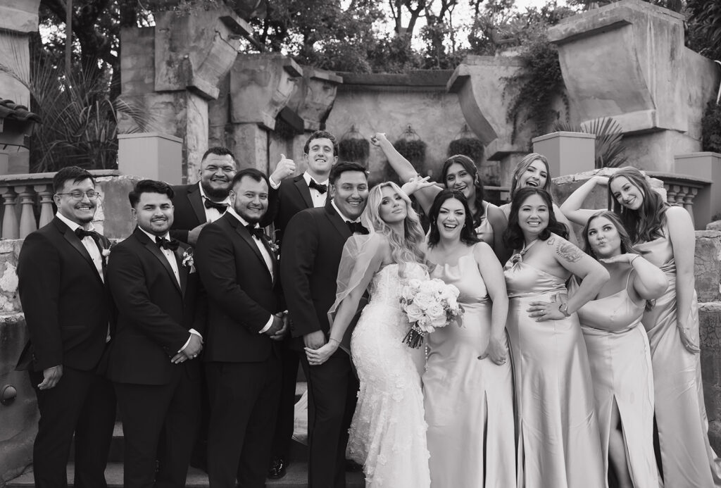 Fun b&w group shot of wedding party with bride and groom at Villa Antonia