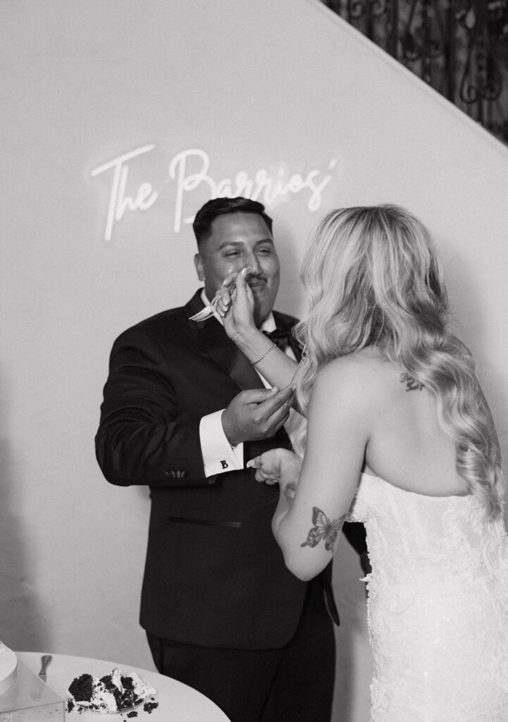 Bride feeding groom cake as they smile and celebrate together 