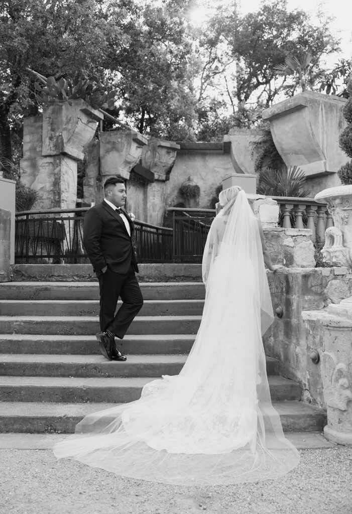 Bride with flowing veil on stone steps at Villa Antonia, romantic couples portrait moment at Villa Antonia wedding reception.