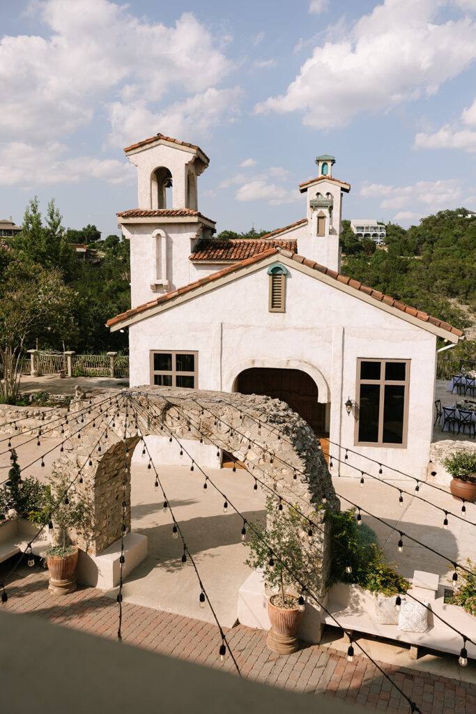 Villa Antonia’s chapel with scenic hill country backdrop and stone archway