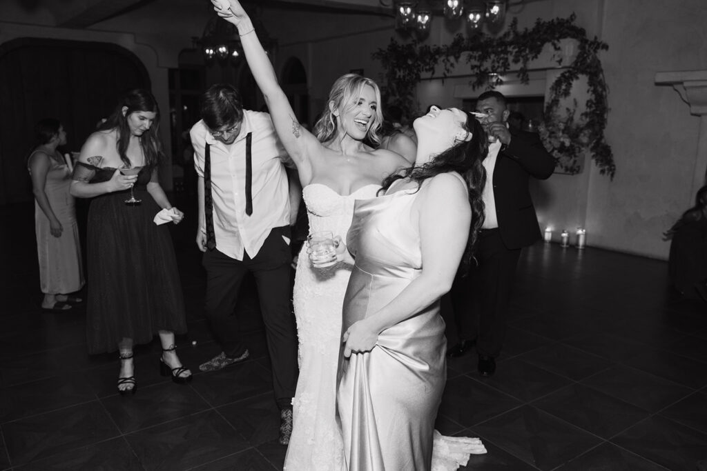 Bride dancing with friends, sharing laughter and fun on the dance floor 