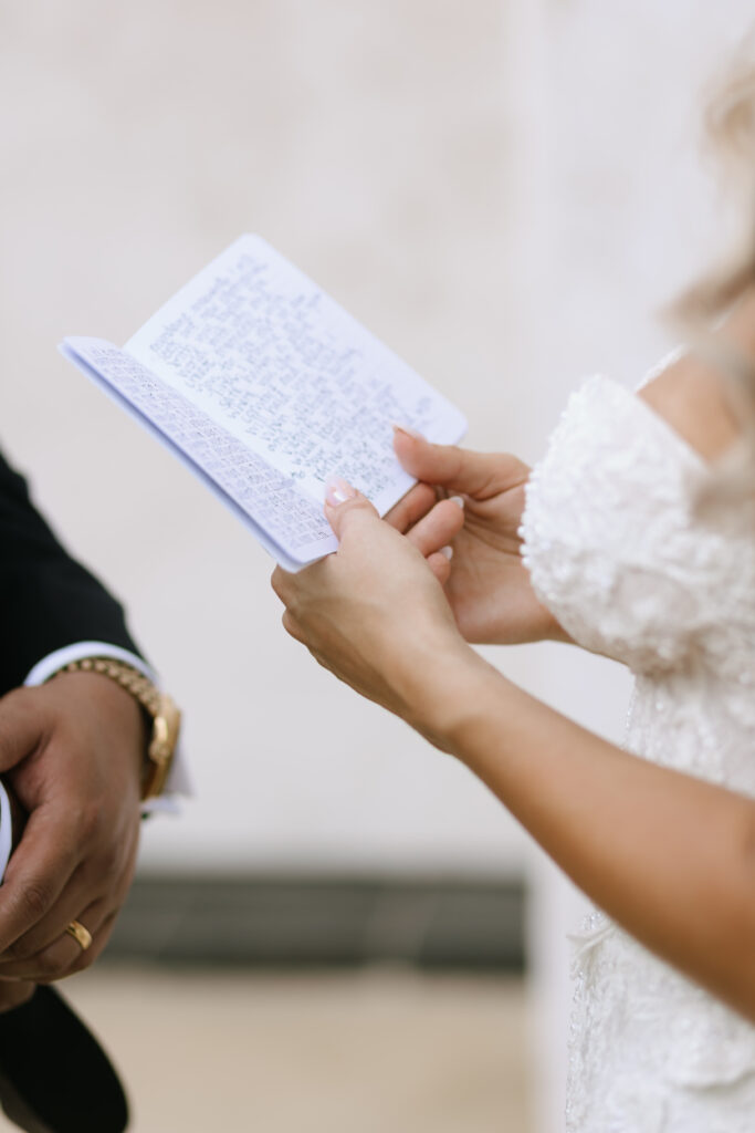 Bride holding handwritten vows at Villa Antonia wedding reception, sharing private vows