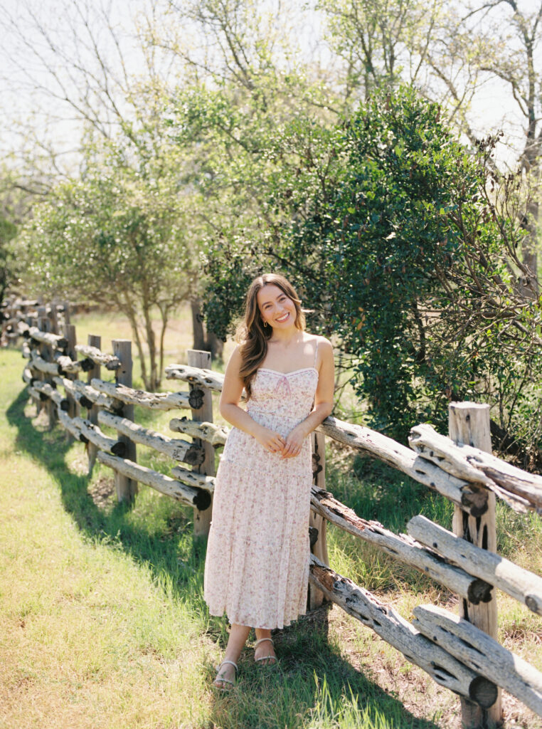 Portrait of Kari standing along a classic Texas Hill Country cedar fence in Fredericksburg Texas