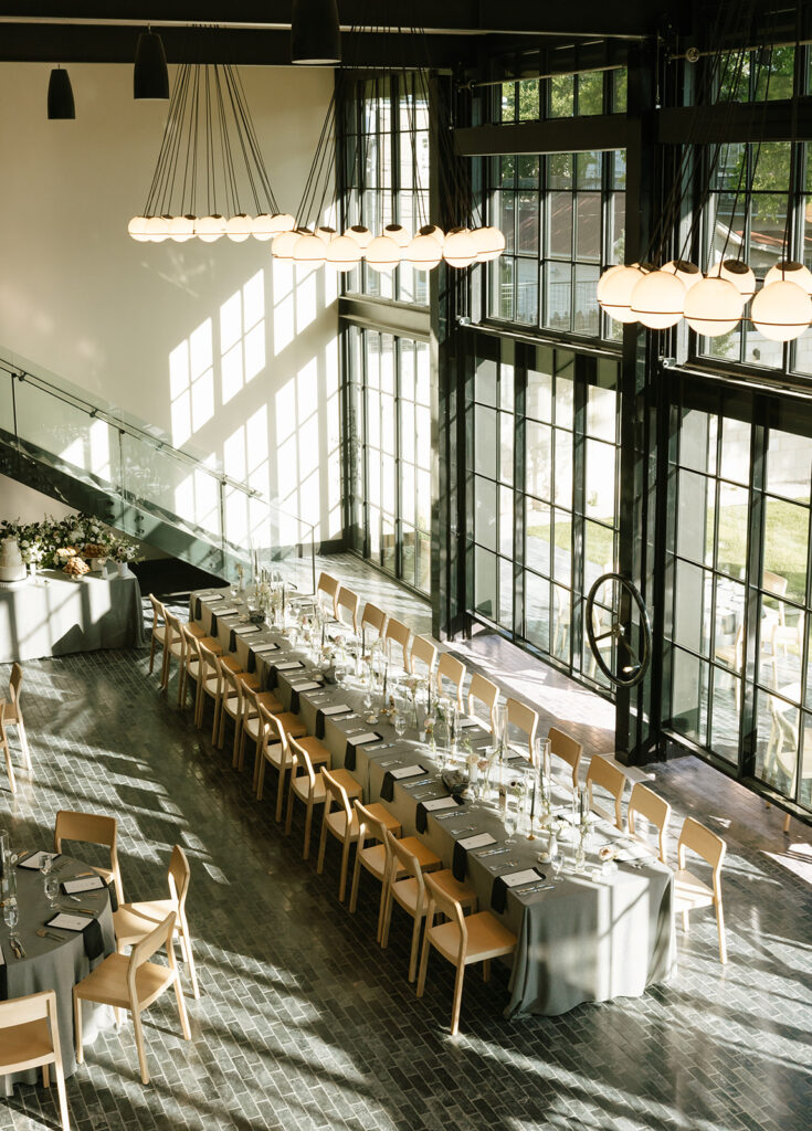 Grand reception hall at Albert Hotel Fredericksburg with long banquet-style tables and modern globe chandeliers.