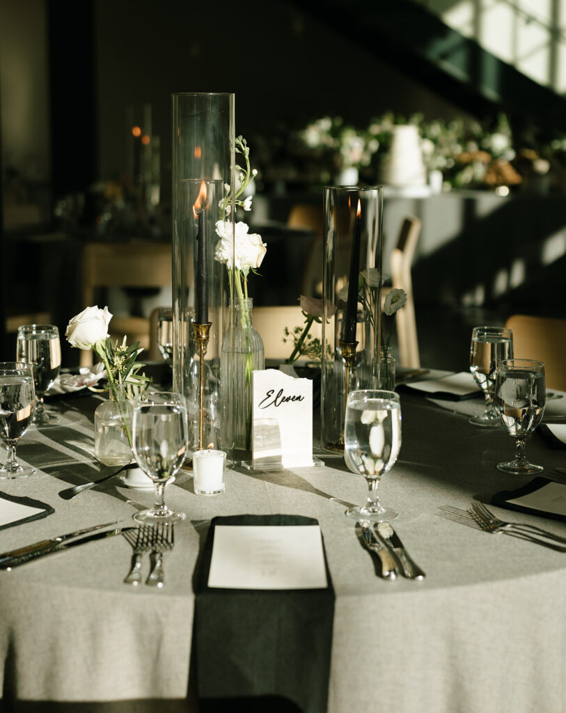 Elegant wedding table setting with tall glass candle holders and soft florals at Albert Hotel Fredericksburg.