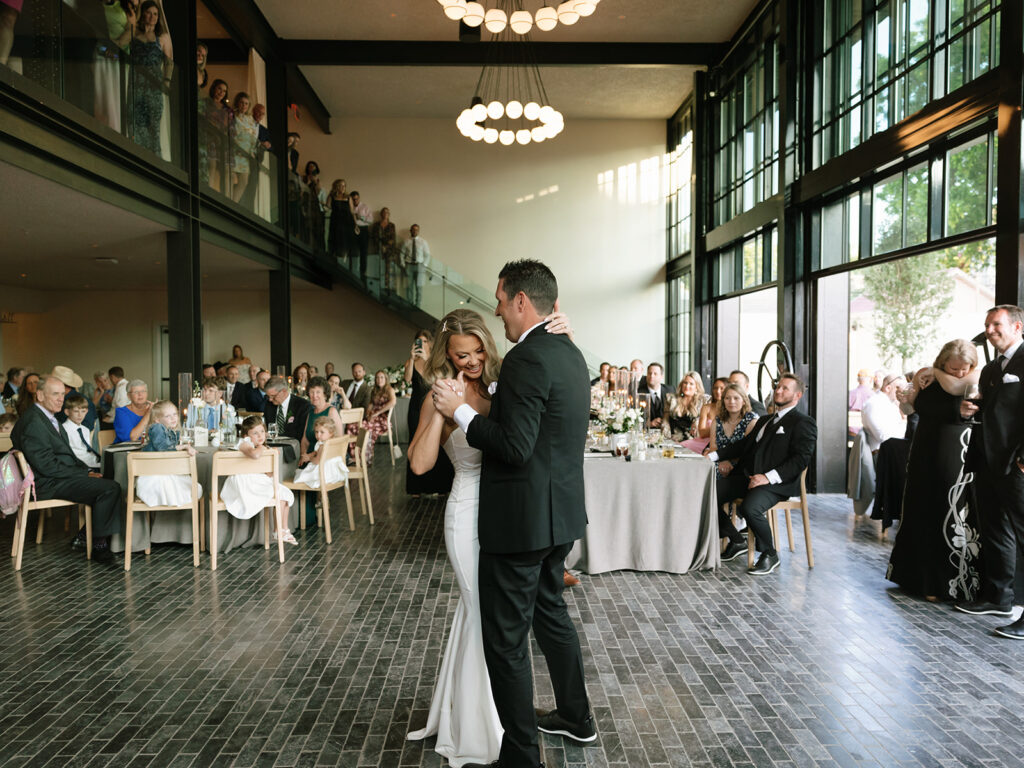 Bride and groom sharing their first dance under modern chandeliers at the Albert Hotel Fredericksburg reception.