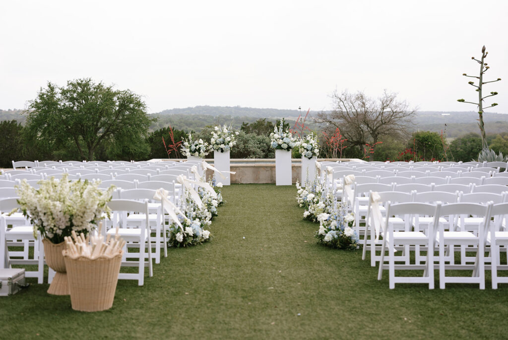 Camp Hideaway Retreats iconic outdoor wedding ceremony space in front of their modern fountain and sprawling Hill Country views in the distance in Fredericksburg Texas
