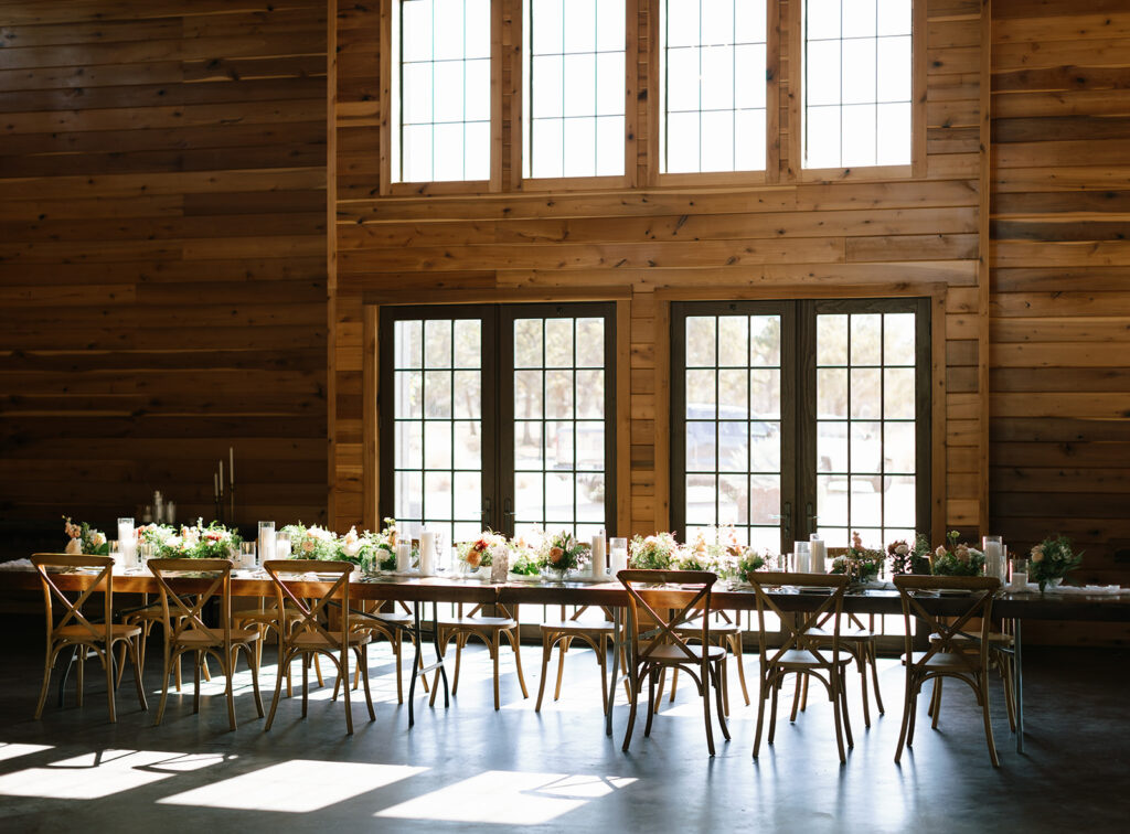 Stunning golden light pouring in the windows at the wood paneled reception space at Swallows Eve in Fredericksburg Texas