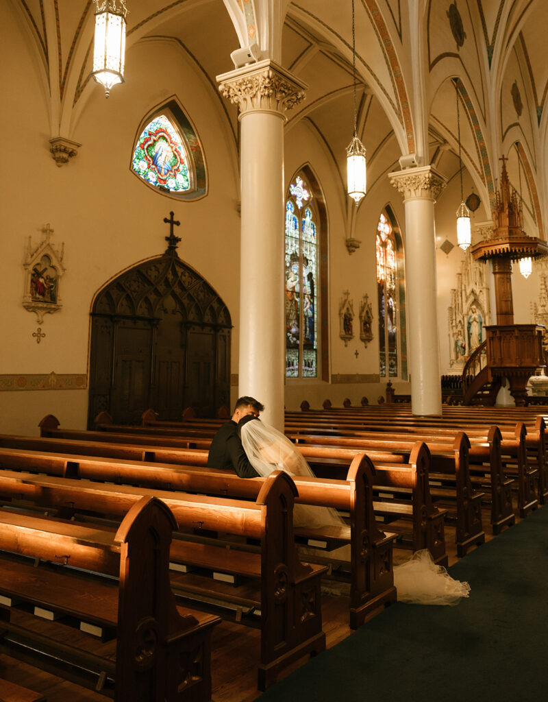 Close-up portrait of Shannon and Austin sharing a quiet moment in their pew, framed by soft evening light inside the Fredericksburg church.
