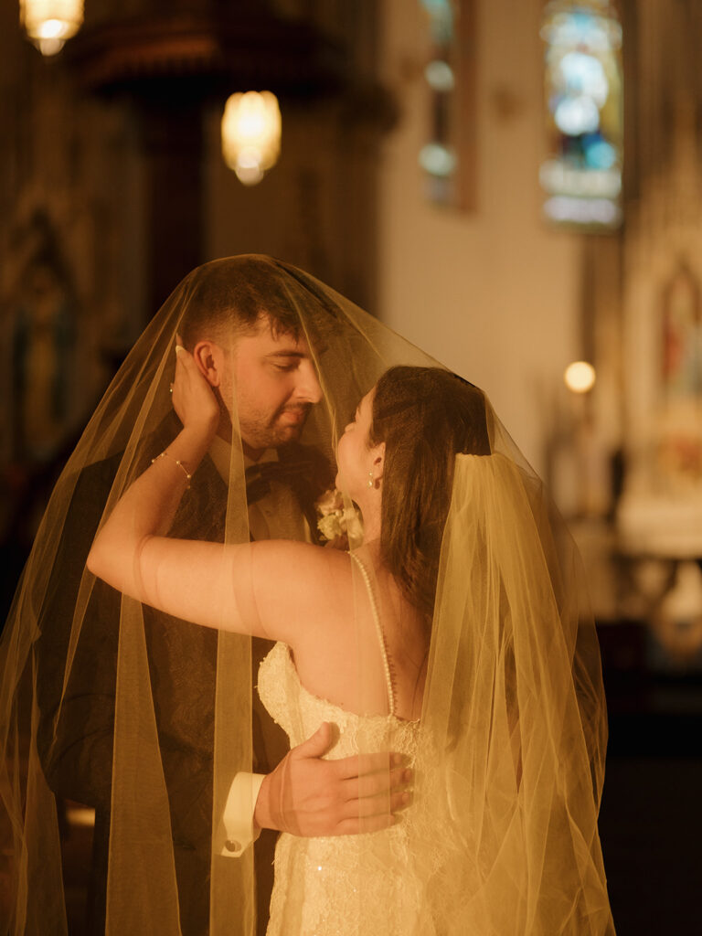 Romantic close-up of Shannon and Austin under her veil during golden hour portraits inside St. Mary’s Catholic Church.