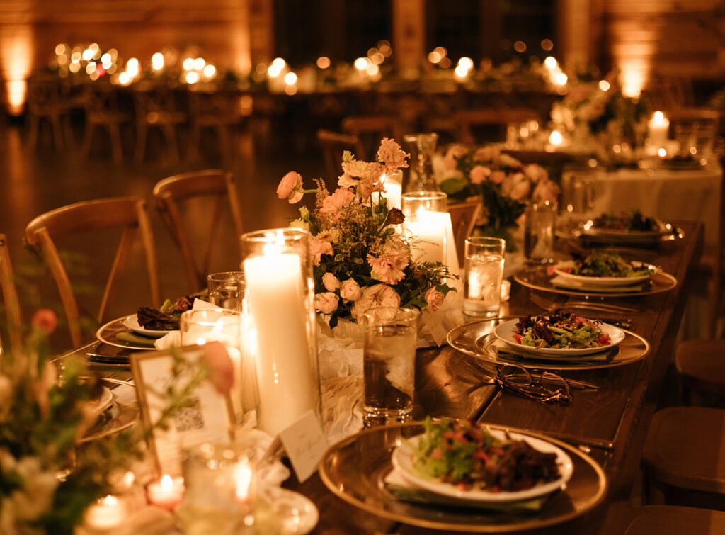 Evening reception table details at Swallows Eve, glowing with taper candles, champagne glassware, and floral arrangements for a warm, romantic feel.