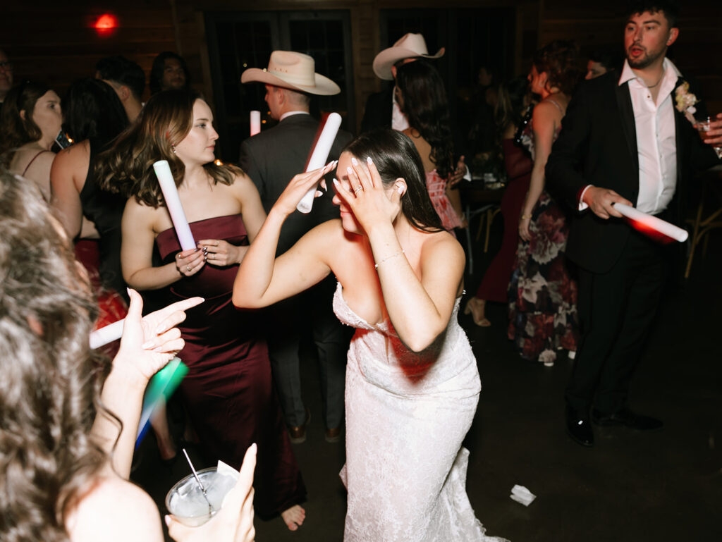 Shannon dancing with friends at the Swallows Eve reception, smiling and hyping each other up under colorful party lights.