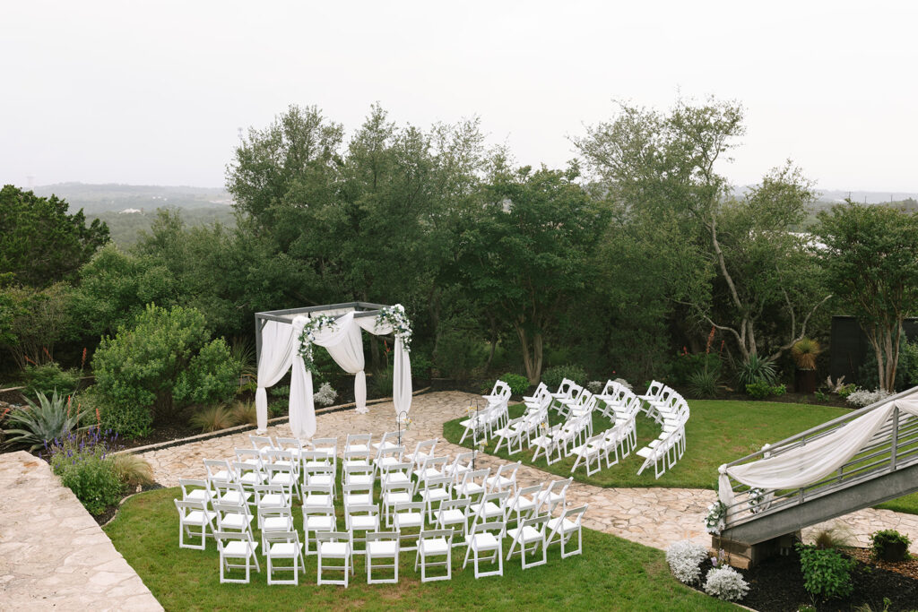 The elegant, back patio outdoor wedding ceremony space at The Terrace Club in Dripping Springs with stunning Hill Country surroundings
