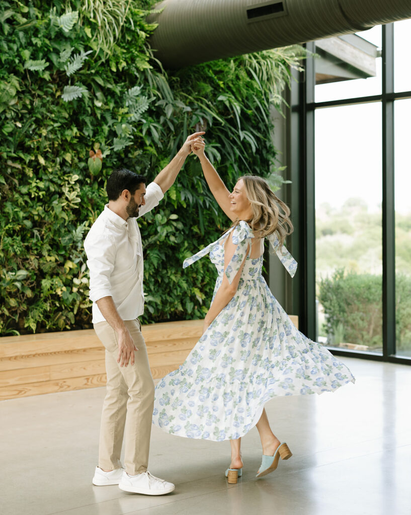 Sara twirling in her blue floral dress during a fun, light-filled moment inside the Walden Retreats event pavilion.