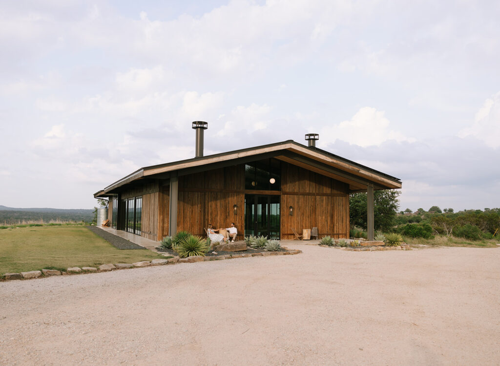 Wide shot of the Walden Retreats event venue in Johnson City, featuring Hill Country views and warm wood tones under a bright Texas sky.