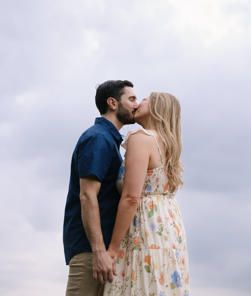 Portrait of the couple sharing a kiss with overcast skies above the Hill Country at Walden Retreats in Johnson City.