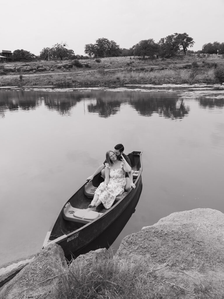 Black and white photo of Sara and Kyle sharing a quiet moment in a canoe on the water at Walden Retreats Johnson City.